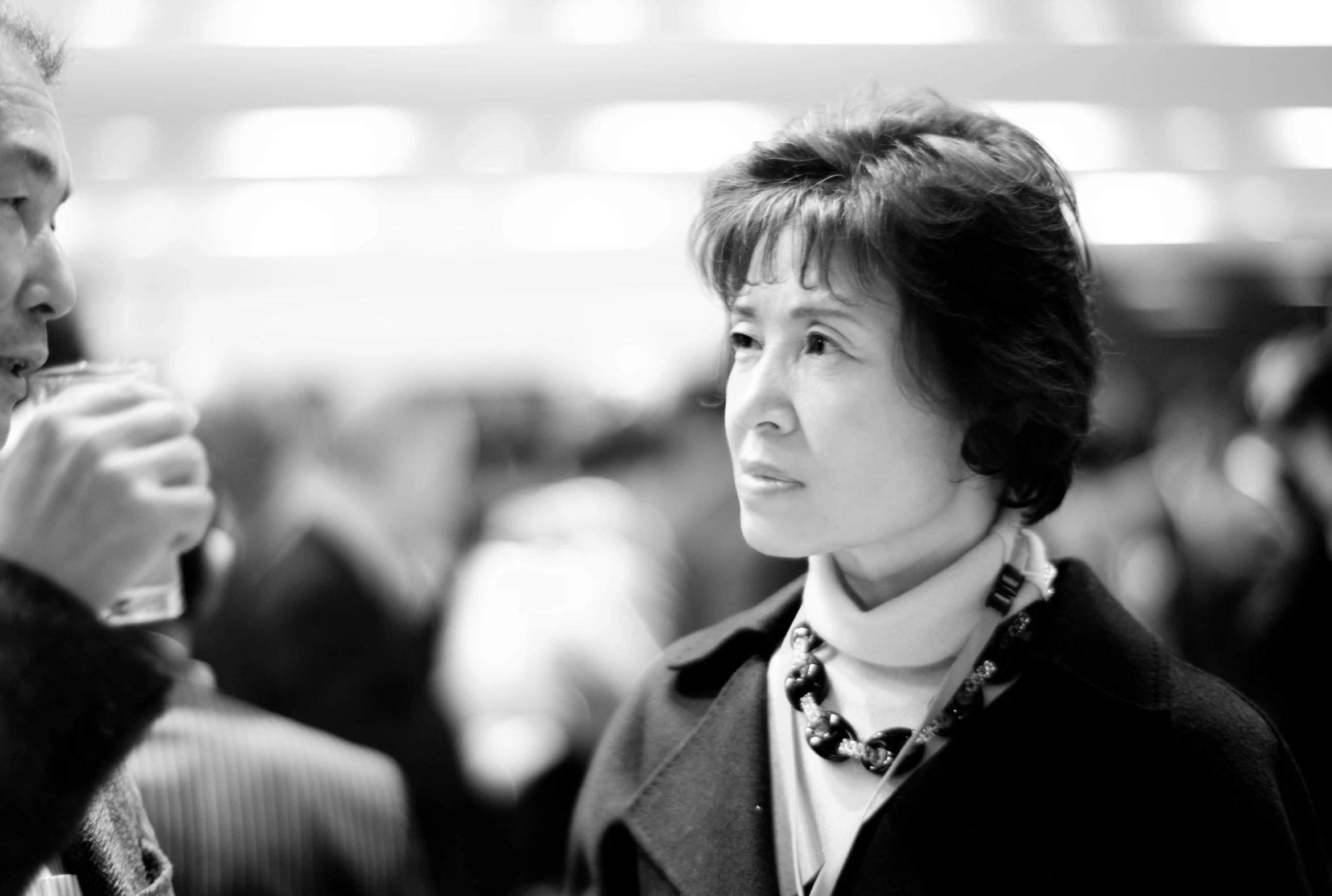 black and white pograph of woman with glasses talking to an older man