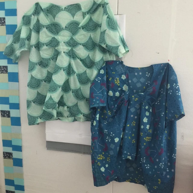 two women's tops hanging on the wall