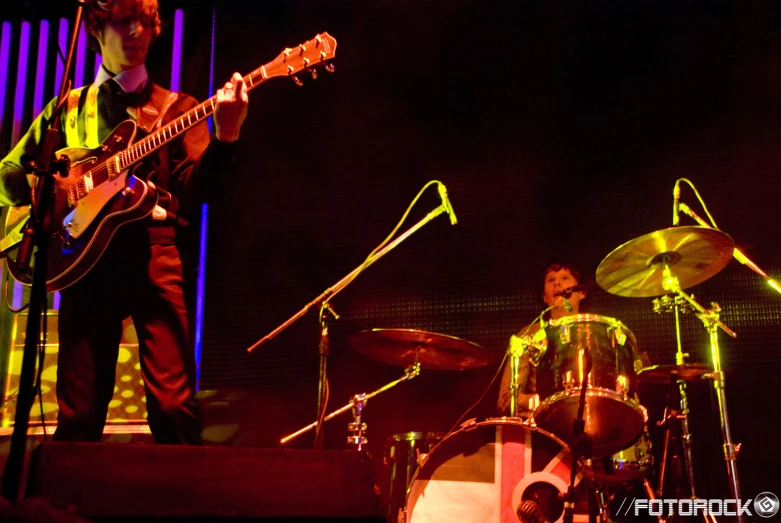 the man is playing on his guitar at the concert