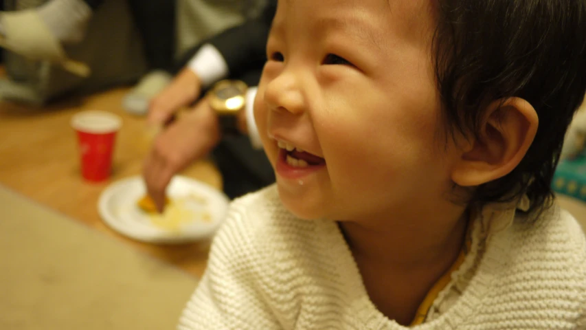 a young child is smiling as she eats