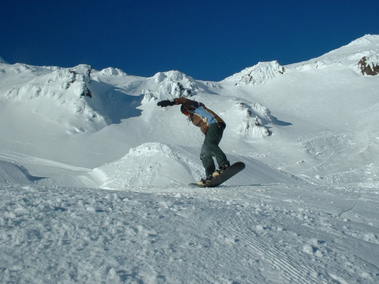 a man snowboarding on a slope with a mountain in the background