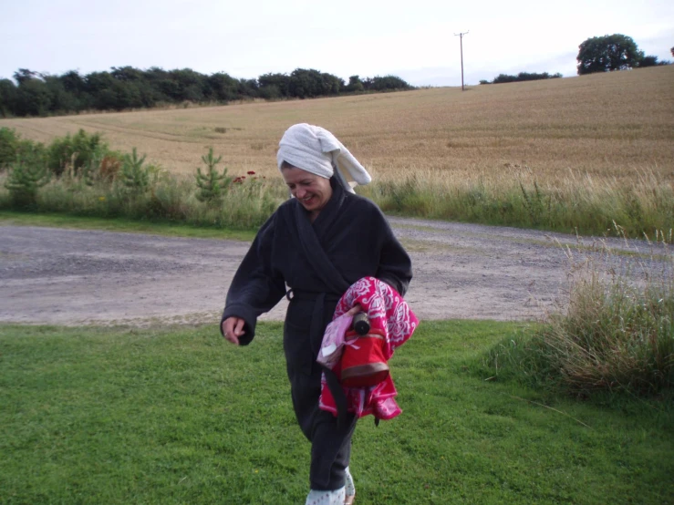 a woman in a robe and hat is walking towards a street