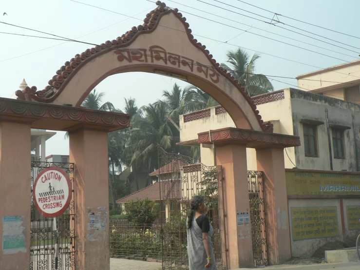 a pink building and an archway with a sign on it