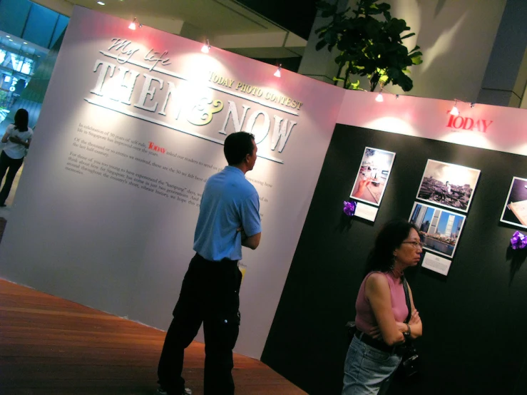 people standing in front of a black and white poster