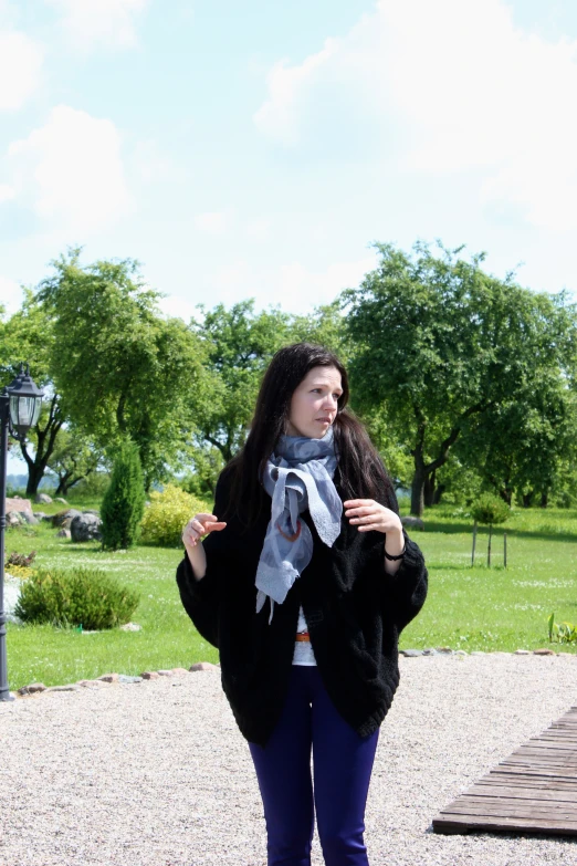 woman in a black furry jacket posing with a scarf on