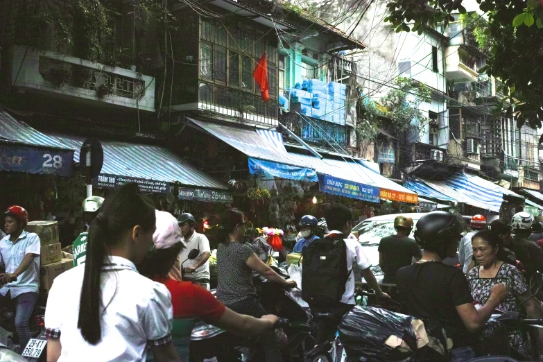 a busy street with many people on motorcycles and various buildings