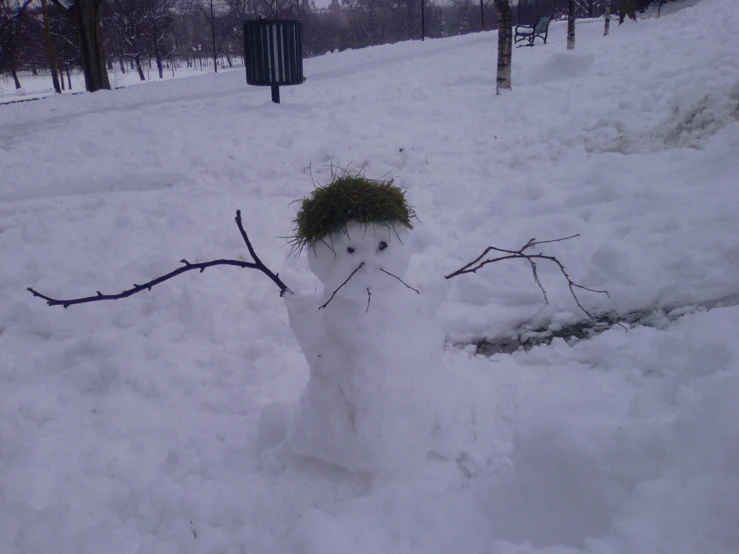 a snowman that has a green hat on it's head