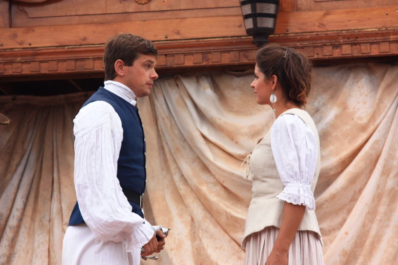 two people are standing near a wooden structure