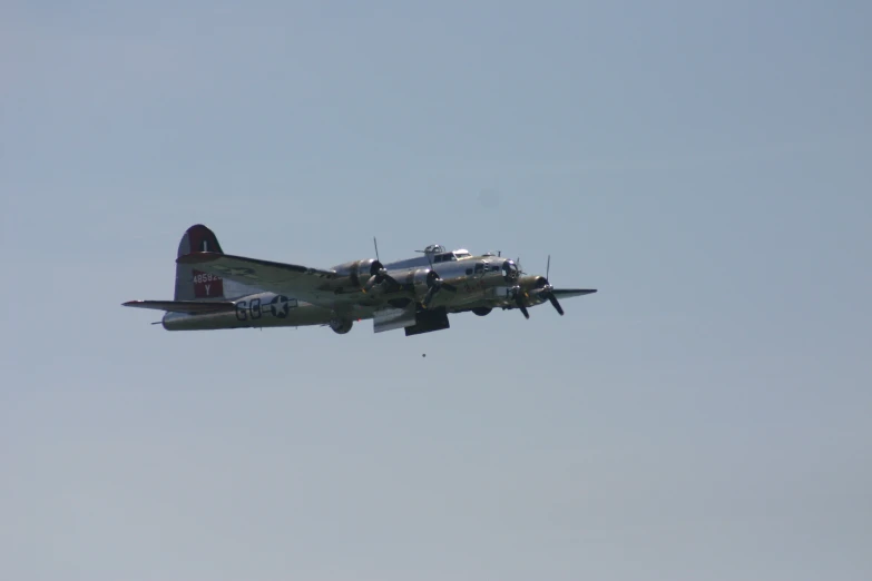an older airplane with the propeller attached flying in the sky