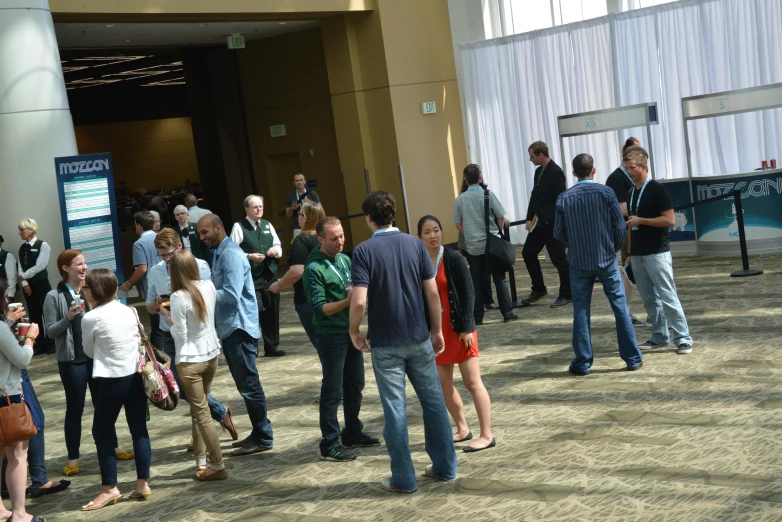 people standing in a long room with people talking