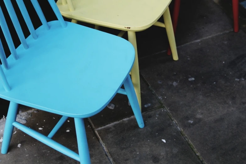 two plastic chairs with one missing the back of the chair