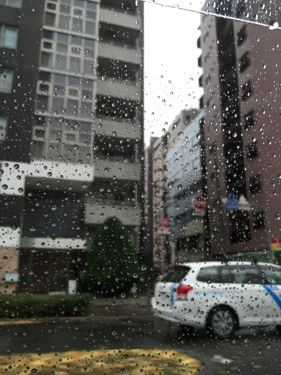 a city street view from an open car window on a rainy day