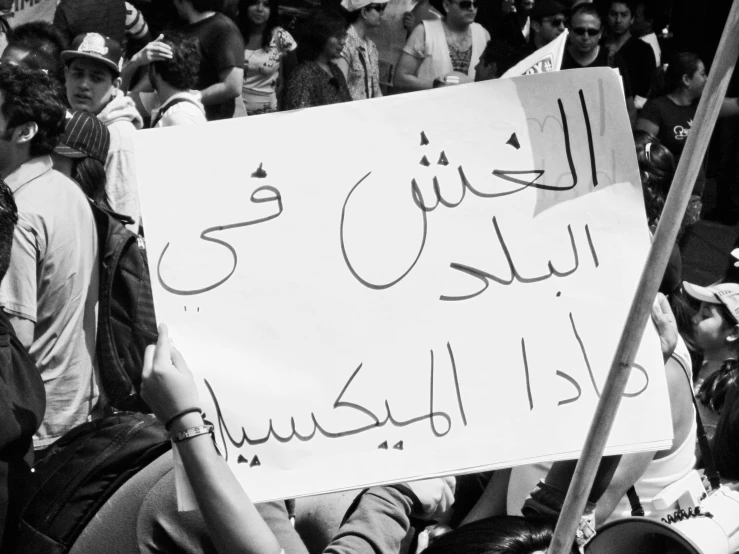 people holding signs with multiple languages in the middle