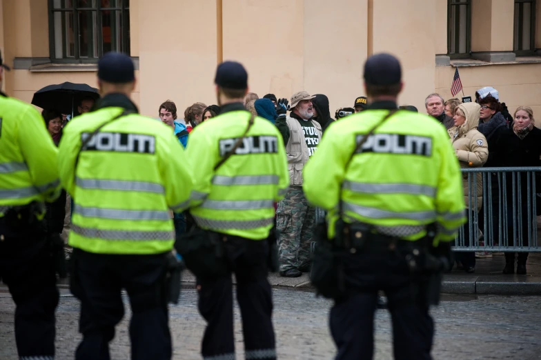 a group of people are standing near police officers