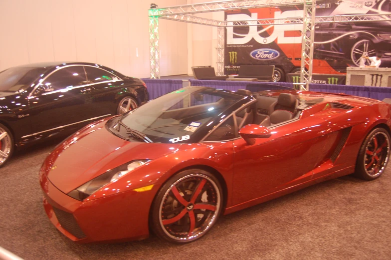 an orange sports car sitting next to black ones