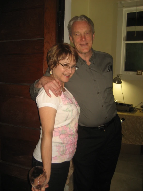 a man and woman in a home with a wooden door