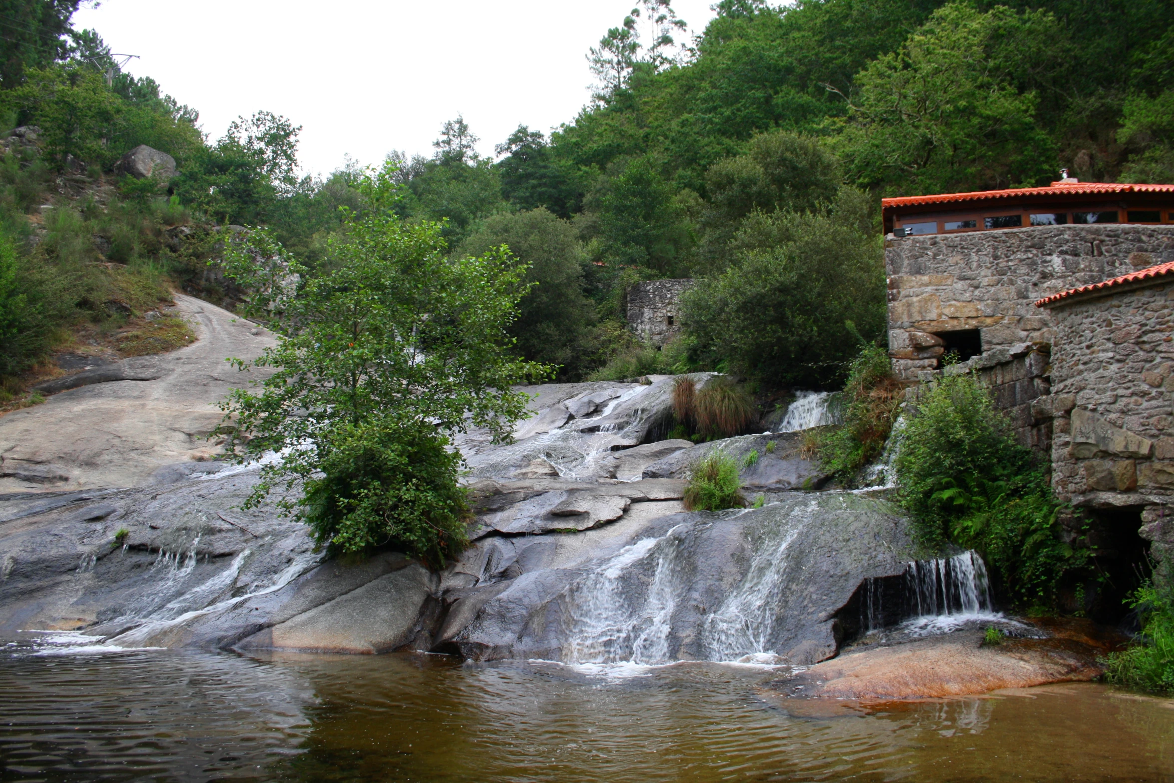 an old, very small waterfall near a small house