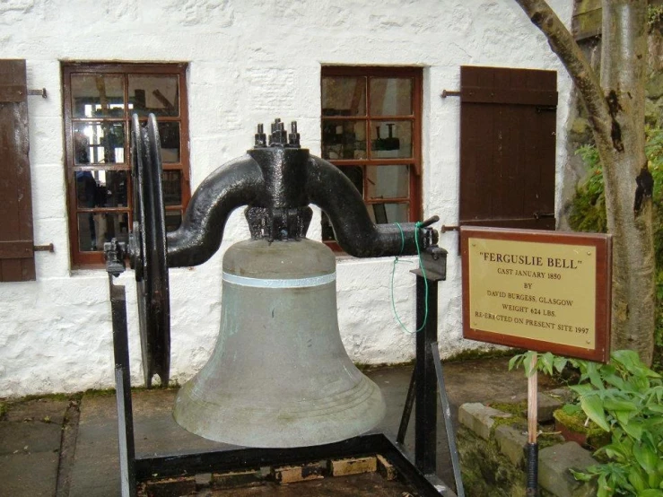 a bell that has a large metal water hose coming out of it