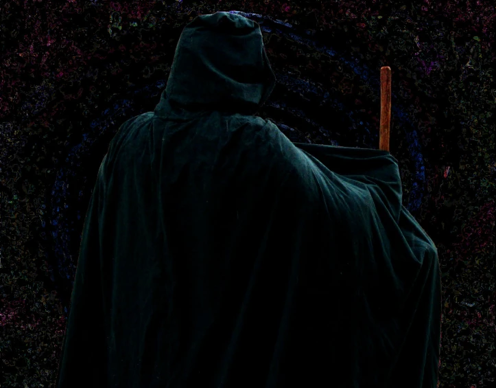 a hooded costumed person dressed in black sitting at an angle