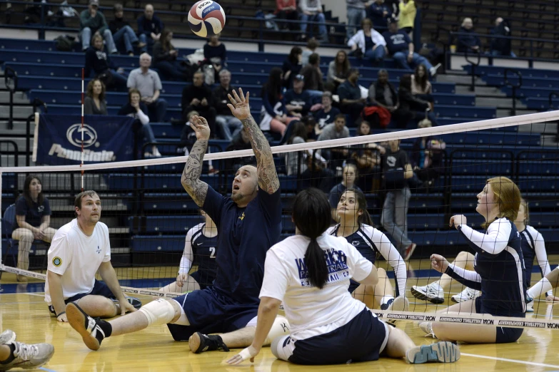 a man playing volleyball, trying to hit the ball