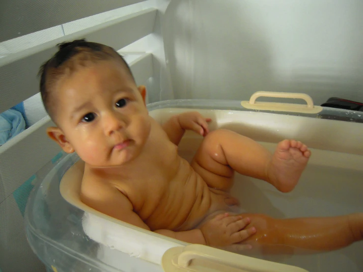 a baby taking a bath in a tub