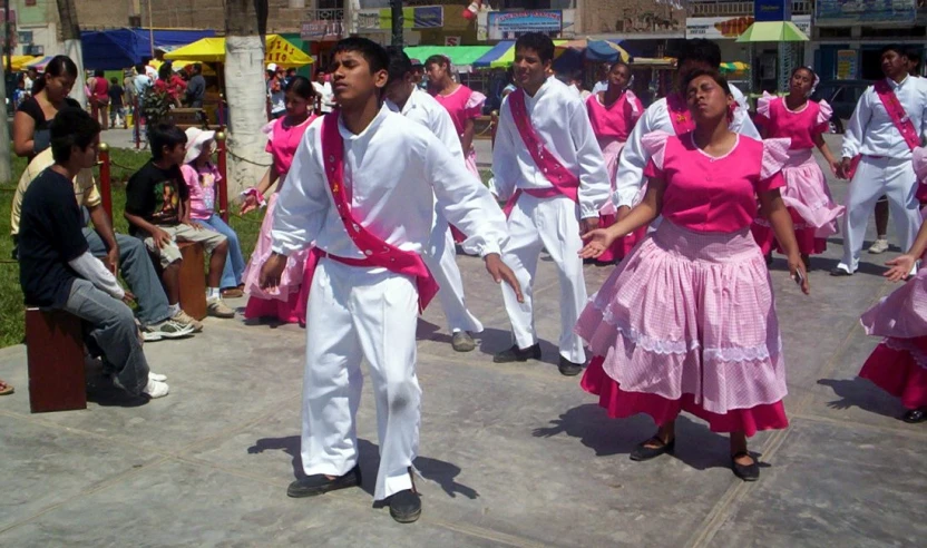 a group of dancers dancing on cement in a park