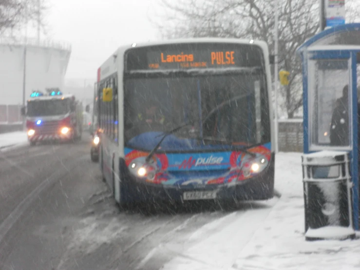 two large buses on a snowy city street