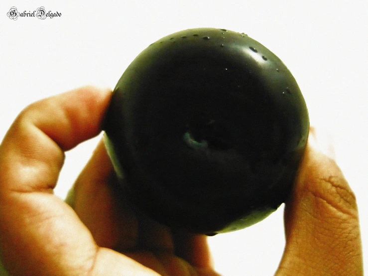 a small black object in a persons hand