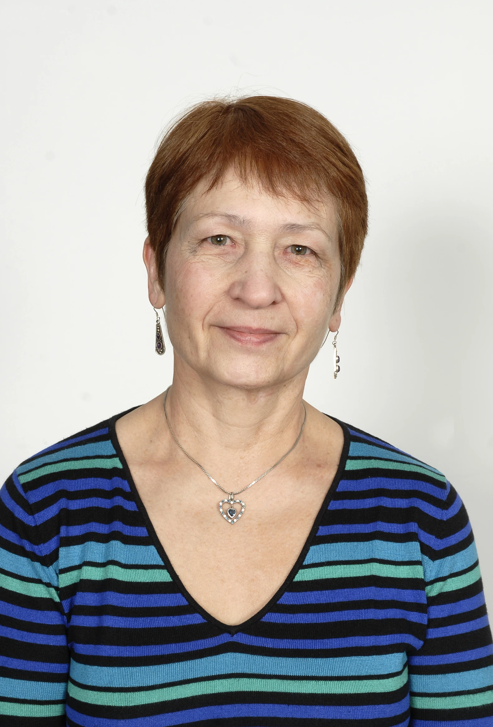 a woman wearing a colorful striped shirt is smiling