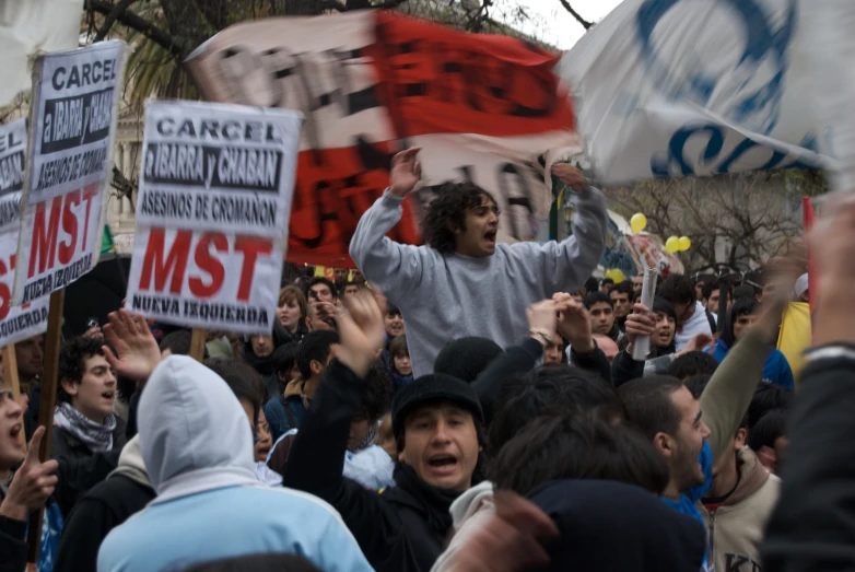 people with signs are standing outside and holding up their hands