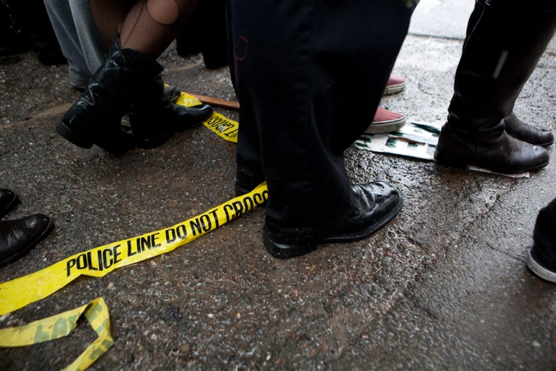 a group of people standing around a yellow tape