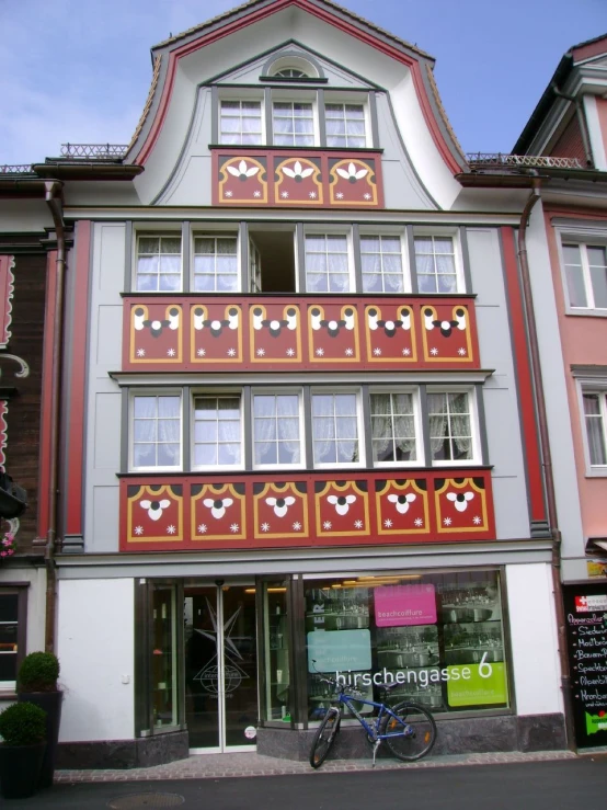 a tall building with lots of windows near a bicycle parked outside