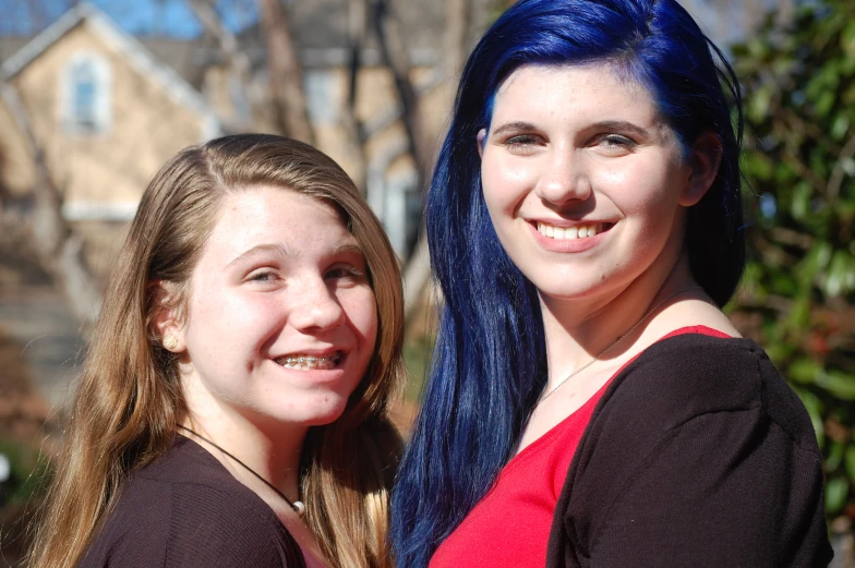 two people are posing for a picture while one is wearing blue hair