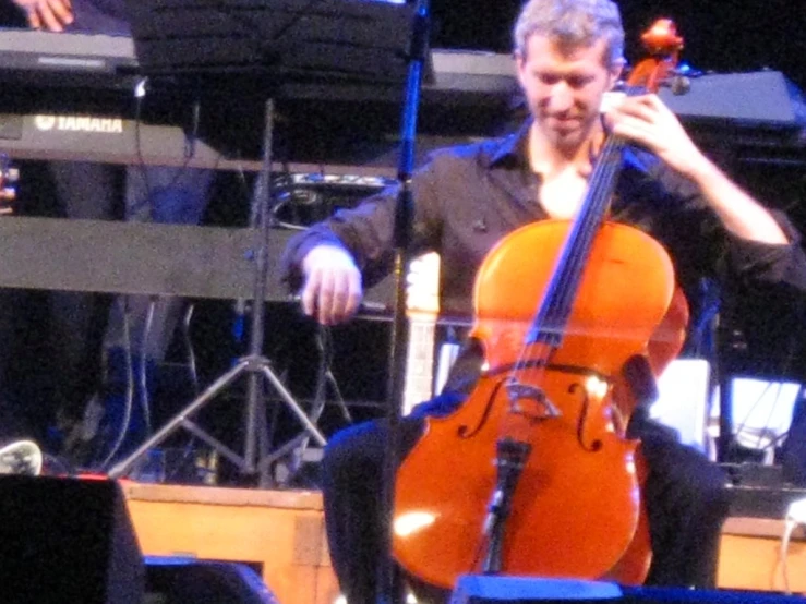 a man playing an orange instrument on stage