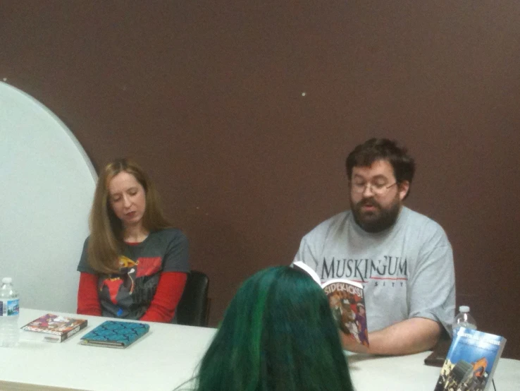 people are seated at a table talking and drinking