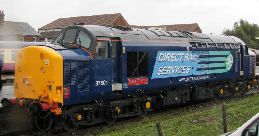 an blue train is on a railroad track