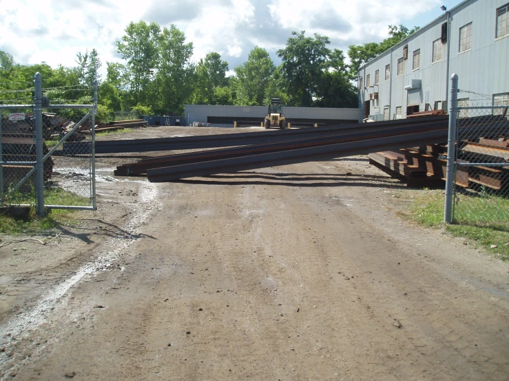 some steel bars are hanging out of the middle of a dirt road