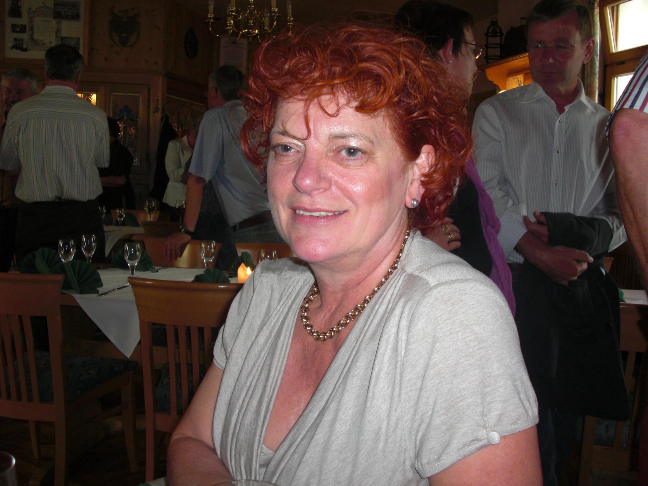 a woman sitting in front of a table smiling for the camera