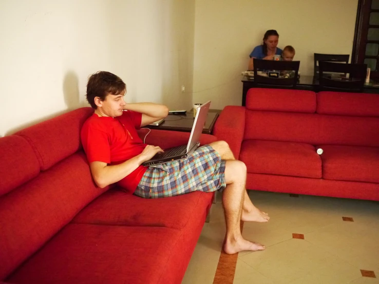 man with laptop sitting on couch in living room