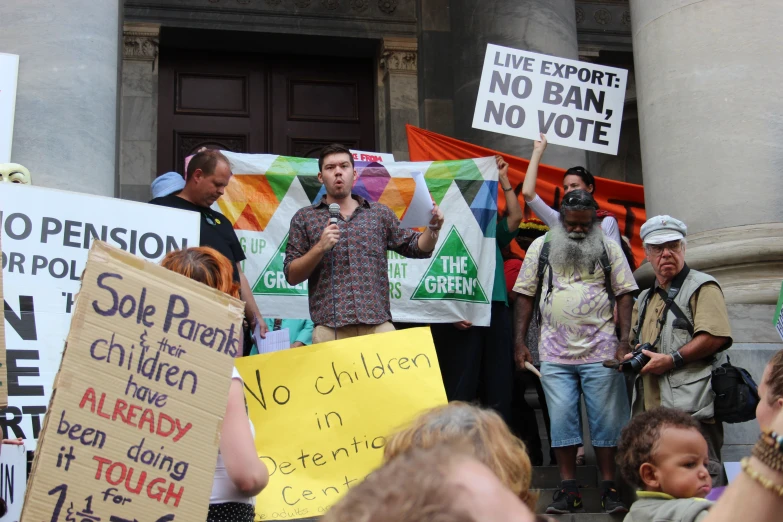 the protest is held outside a building while people hold up signs