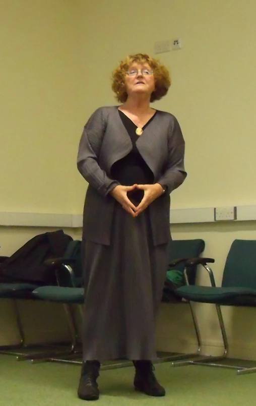 a woman stands by a lecture hall and looks at the camera