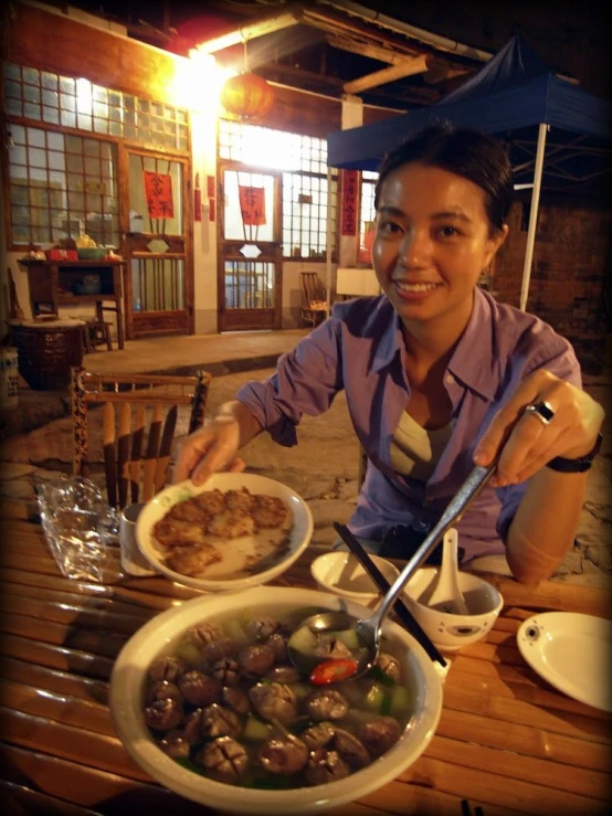 a woman with an asian style dinner in a restaurant