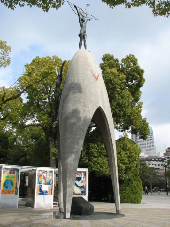 the statue is standing near trees, and it is large