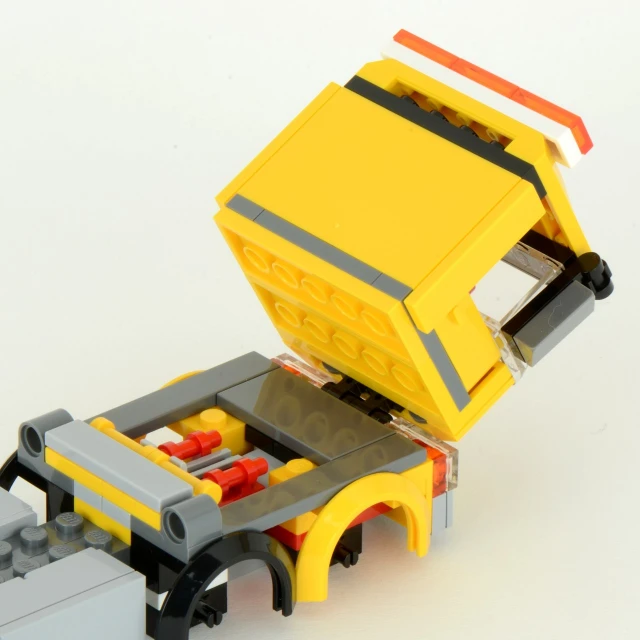 a yellow toy truck with its open back door