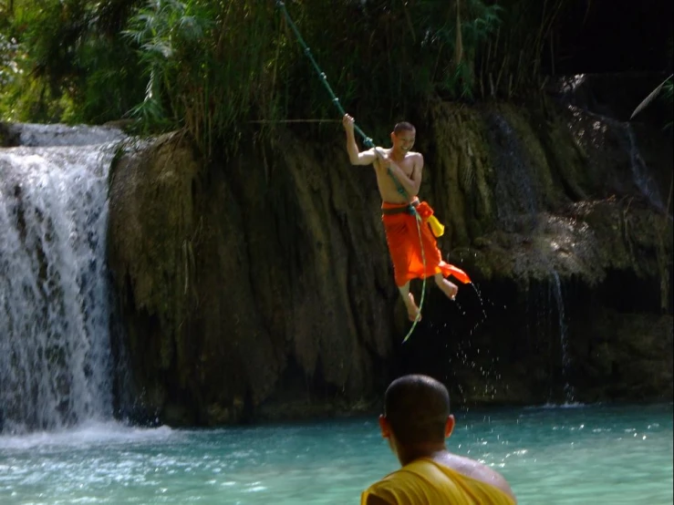 a man flying through the air over a waterfall