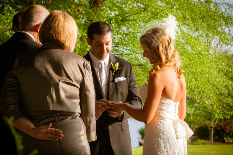 a couple getting married by a priest and a lady in the crowd