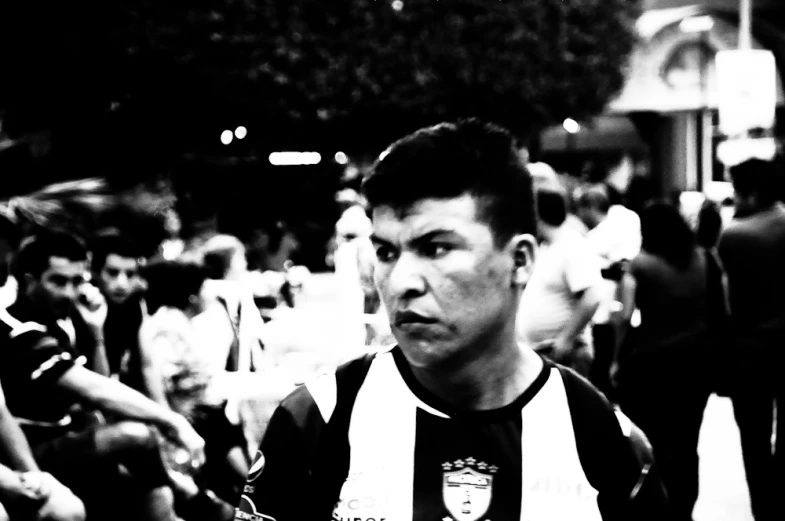 a black and white po of a young man standing in a crowd of people