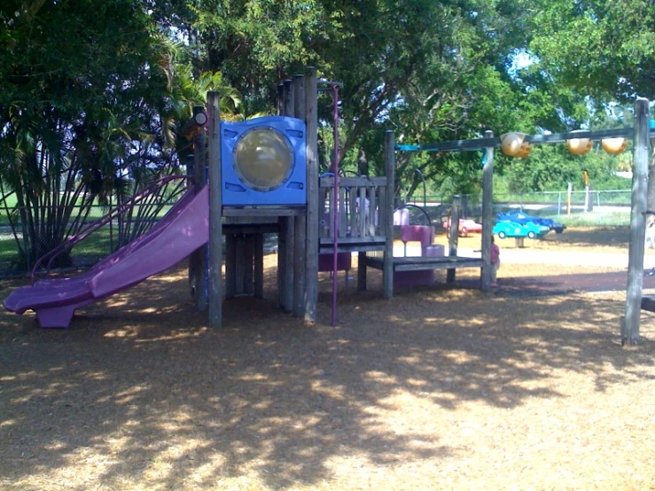 a playground with a slide in the middle and a purple slide