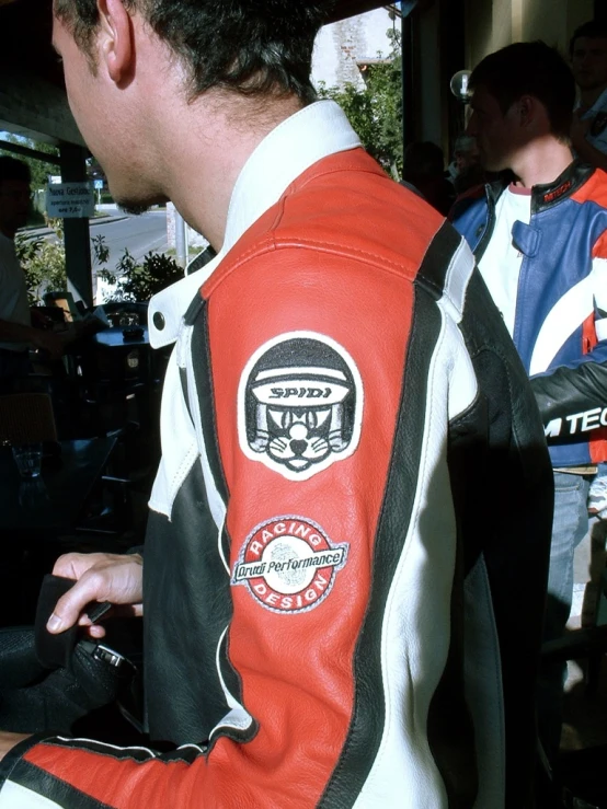 a man in red jacket and white vest standing near a man in black and white jacket