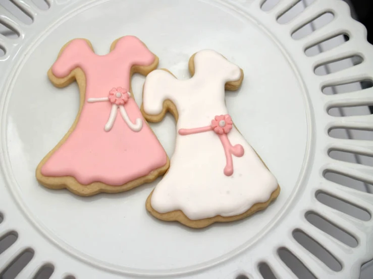 two decorated cookies on a white plate on a table